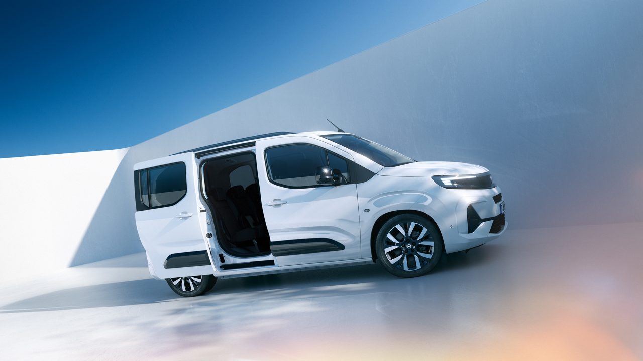 Pogled s strani na bel Opel Combo z drsnimi vrati