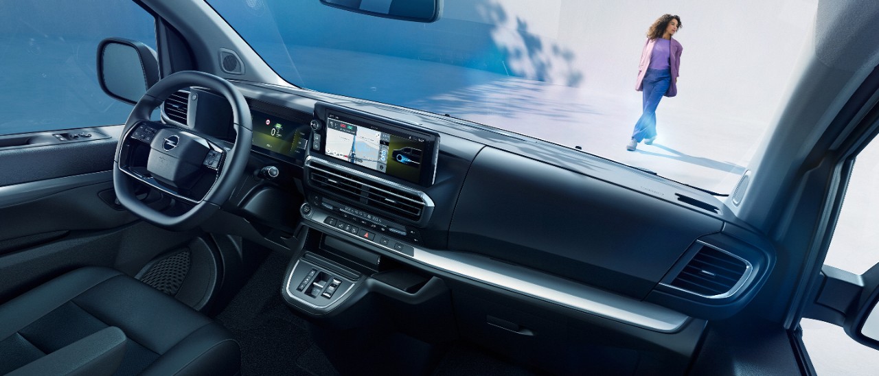  Pogled v notranjost bele Opel Zafire Electric s sovoznikovega sedeža, zunaj stoji ženska