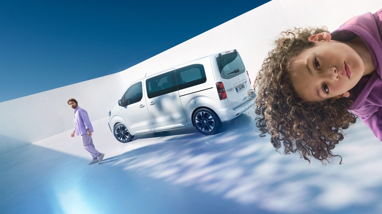 Moški in deček z belo Opel Zafiro v ozadju